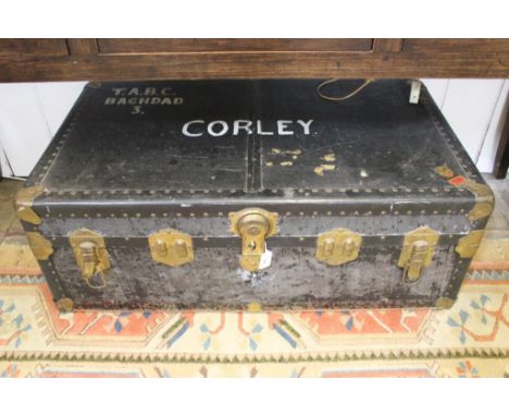 A vintage brass bound travel trunk with compartmented interior