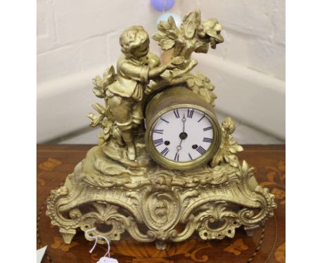 A 19th century French-style ormolu mantle clock with elaborate carving and profuse fret work, surmounted by a young boy with 