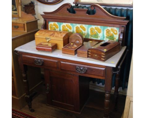 An Arts and Crafts mahogany marble top wash stand with swan neck carving to the gallery, multi-coloured floral tiles, two dra