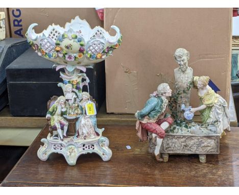 A (possibly German) elaborately decorated table centrepiece with a pierced basket on top decorated with flowers and foliage, 