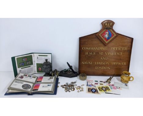 A mixed lot to include a naval plaque, naval related badges and cufflinks, brass model of a canon first day covers, coins and