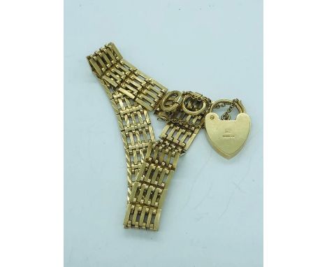 A 9ct yellow gold gate bracelet with heart shaped fastener and a safety chain, (15.1g)