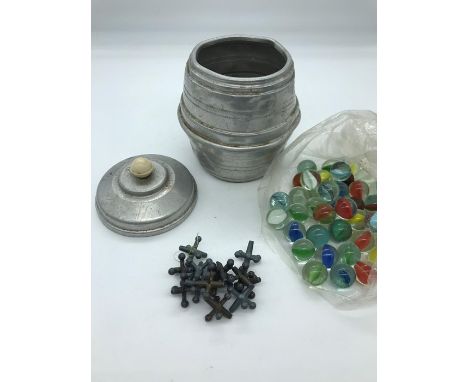 A Metal barrel containing vintage marbles and jacks