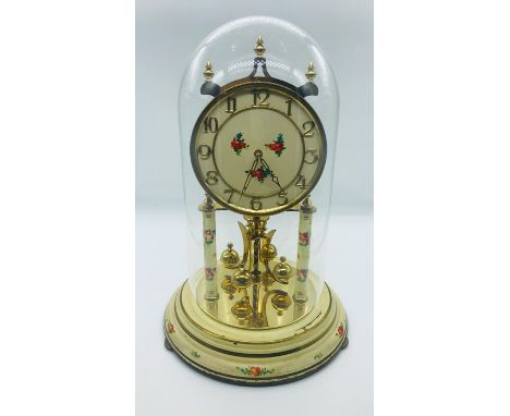 A Decorative Clock under a glass dome.