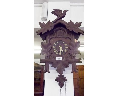 A cuckoo clock with bird and vine decoration 