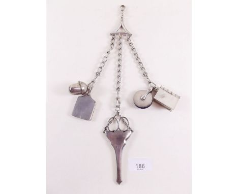An early 20th century silver plated chatelaine with pin cushion, pill box, thimble holder, scissors, notebook 
