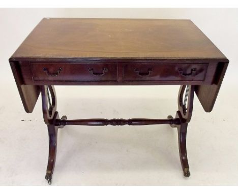 A reproduction mahogany sofa table on lyre supports 