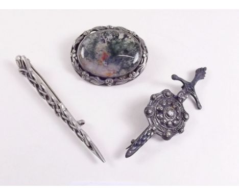Two Scottish silver Celtic brooches and an oval silver brooch set moss agate 