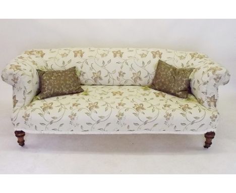 A Victorian cream floral upholstered sofa all on turned supports and castors 