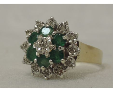 A lady's dress ring having an emerald and diamond chip triple cluster in an illusionary mount on a 9cy gold loop, size P