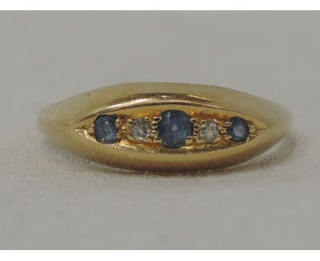 A lady's dress ring having three powder blue sapphires interspersed by two diamonds in a bead set gallery mount on an 18ct go