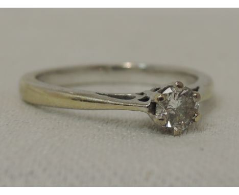 A lady's diamond solitaire dress ring,  approx 0.25ct in a claw set mount to knife blade shoulders on a white metal loop stam