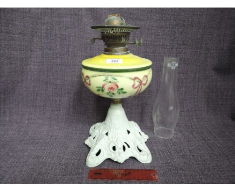A Victorian oil lamp having yellow painted reservoir, on painted cast base