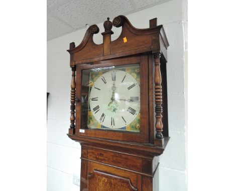 An early 19th century oak and mahogany longcase clock having swan neck and pillar hood containing painted dial and 30 hour mo