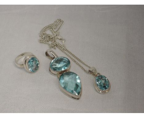 Three pieces of white metal jewellery stamped 925 having blue topaz stones including large pendant, ring and pendant with cha