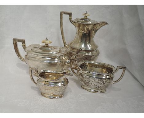 A four piece silver tea set of oval form having moulded decoration, ivory finials, flush hinged lids to lipped rims and archi