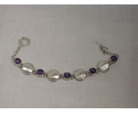 A white metal articulated bracelet stamped 925 having mother of pearl and amethyst style stone panels in collared mounts with