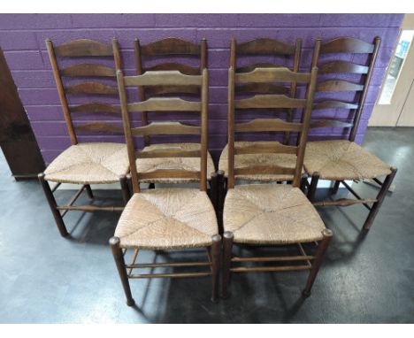 A set of four early 20th century stained frame kitchen chairs having ladder backs with rush seats and turned legs and two sim