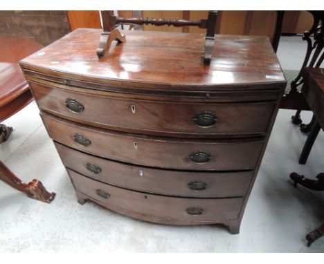 An early 19th century mahogany bow front chest of four long graduated drawers, with brushing slide, on splay legs