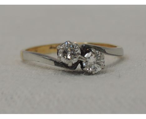 A lady's dress ring having two diamonds, approx .25ct in claw set mount to cross over shoulders on an 18ct gold loop, size H1