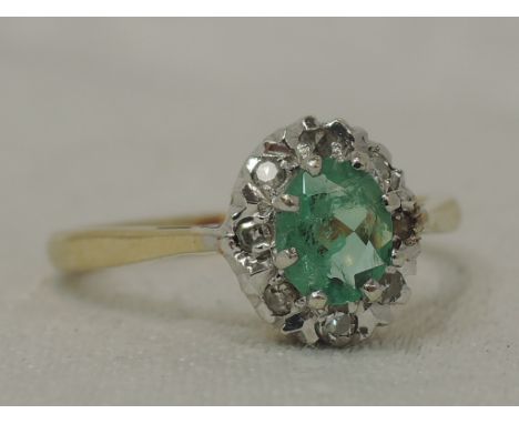 A lady's dress ring having an emerald style and diamond chip cluster in a claw set mount on a 9ct gold loop,  size K