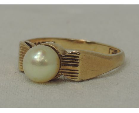 A lady's dress ring having a single cultured pearl in a collared mount to butt shoulders on a 9ct gold loop,  size P