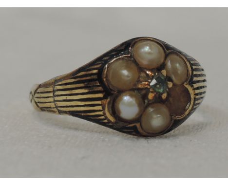 A Victorian lady's mourning ring having a central old cut green diamond chip within a seed pearl cluster to black enamelled s