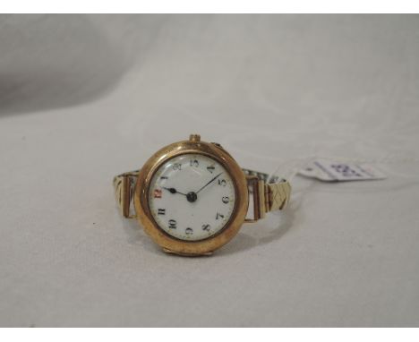 A lady's vintage 9ct gold wrist watch having an Arabic numeral dial with gilt minute dots to white enamel face on a later gol