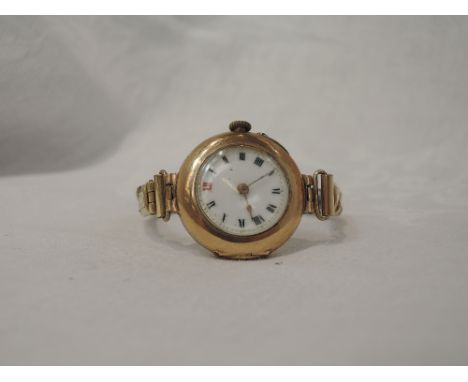 A lady's 9ct rose gold vintage wrist watch having Roman numeral dial with gilt minute dots to white enamel face with later go