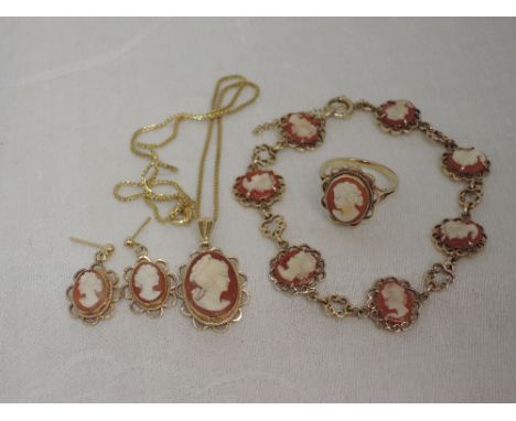 A four piece 9ct gold conche shell cameo suite comprising panelled bracelet, pendant, stud drop earrings and dress ring all b