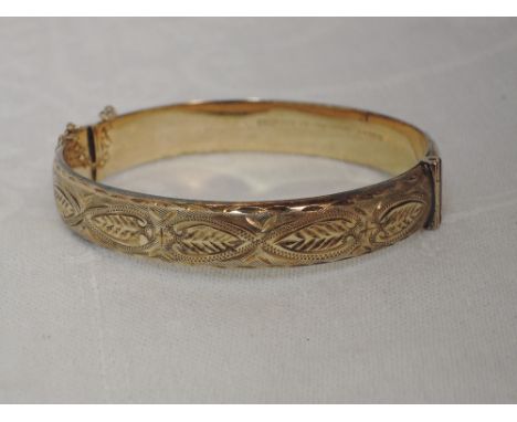A 9ct gold hinged bangle having engraved decoration,  approx 12.8g