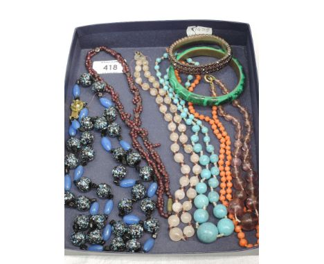 Six strings of beads of various forms including coral, amethyst style, a hinged Victorian style bangle having red paste stone