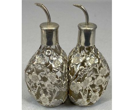 PAIR OF CHINESE SILVER MOUNTED SCENT BOTTLES, dimpled format glass with prunus blossom overlay and hinged pourers to the cork