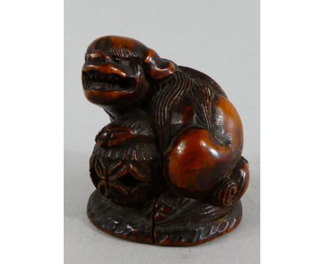 A 19th Century Netsuke. Carved as a Temple Lion and with Black Glass Eyes. 4cm Tall