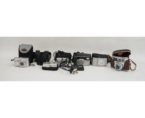 Kodak Retinette 1B camera, a Canon IXUS digital camera, a pair of Practika binoculars, a Panasonic Lumix digital camera, an O