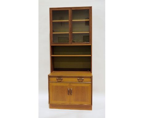 Mid-century modern teak G-Plan lounge display cabinet with two glazed doors enclosing shelves above open shelf, the base of s