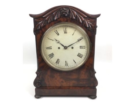 A Victorian mahogany bracket clock, the case with arched top and applied foliate decoration, fluted feet, and ring handles to