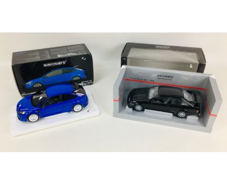 Two Minichamps 1:12 scale die-cast model Ford cars, a 2010 Ford Focus RS in blue, and a 1988 Ford Sierra RS in black, both wi