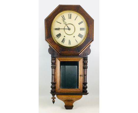 A Victorian mahogany wall clock, octagonal frame and turned decorative finials, with pendulum. 