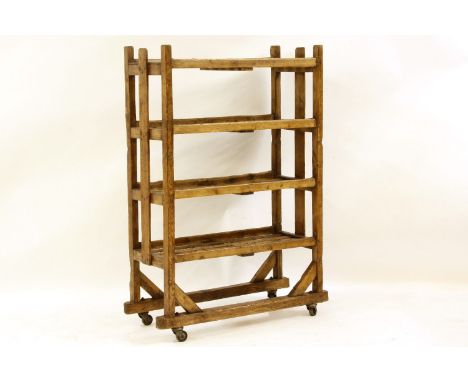 A Colonial softwood open shelf, with slatted ends and iron casters, 84cm wide, 37cm deep, 130cm high