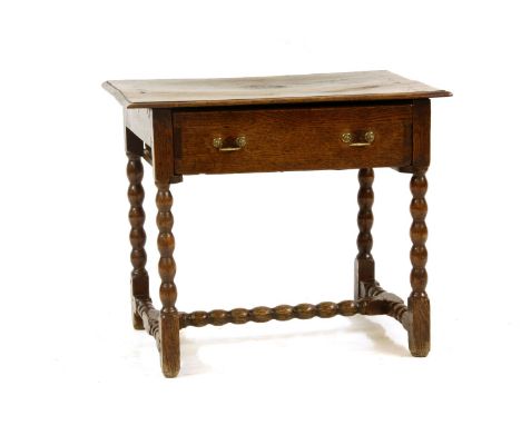 An 18th century oak side table, with single drawer, and on bobbin turned legs united by a stretcher, 84cm wide, 55cm deep, 70