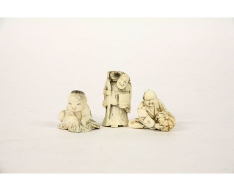 A late 19th century ivory netsuke of a gentleman holding a gourd, together with two further bone examples (3)