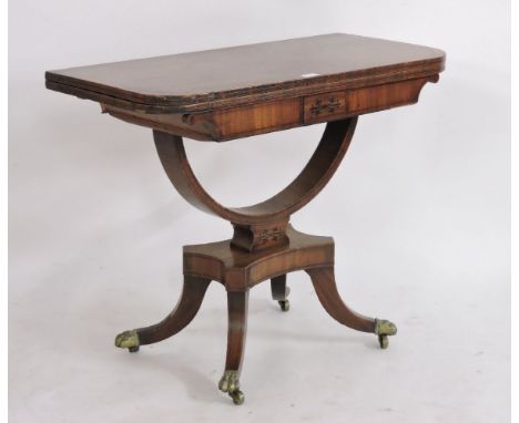 A Regency mahogany and inlaid fold card table, the fold over top on bowed support, platform base and four sabre legs terminat