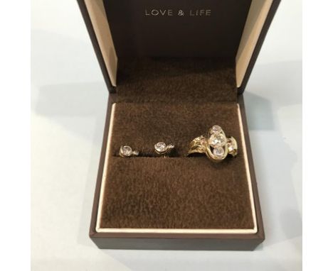 An 18ct gold ring set with three diamonds, central stone 0.57ct and a pair of diamond earrings