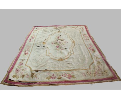 TWO AUBUSSON CARPET FRAGMENTS, probably 19th century, the first with a floral medallion on an ivory field, the second with a 