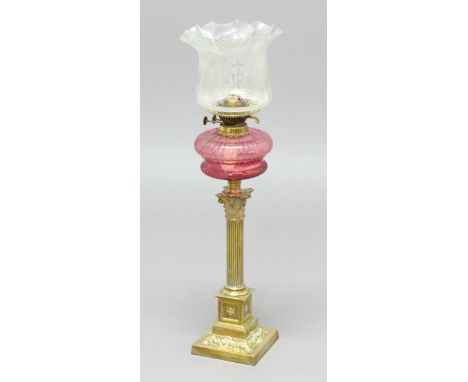 VICTORIAN OIL LAMP, the etched glass shade above a cranberry glass reservoir and brass corinthian column base, height 72cm