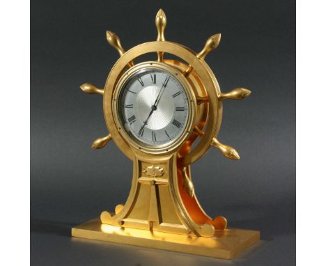 GILT BRASS SHIP'S WHEEL MANTEL TIMEPIECE, the 4 1/2" silvered dial with engine turned centre and Roman numerals on a brass mo