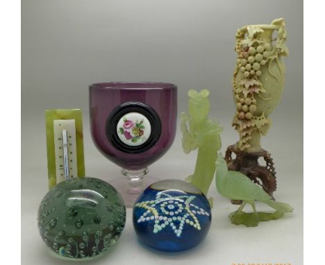 A soapstone carving, two other carved figures, a thermometer, two glass paperweights and a large glass with plaque