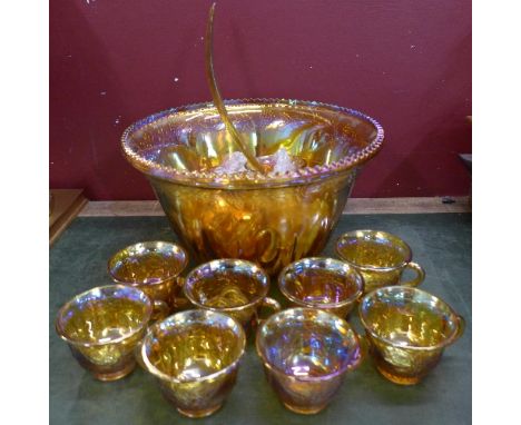 A carnival glass punch bowl set, twelve cups and a ladle