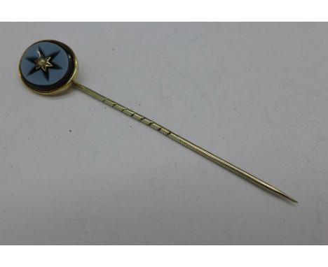 A yellow metal stick pin set with a seed pearl